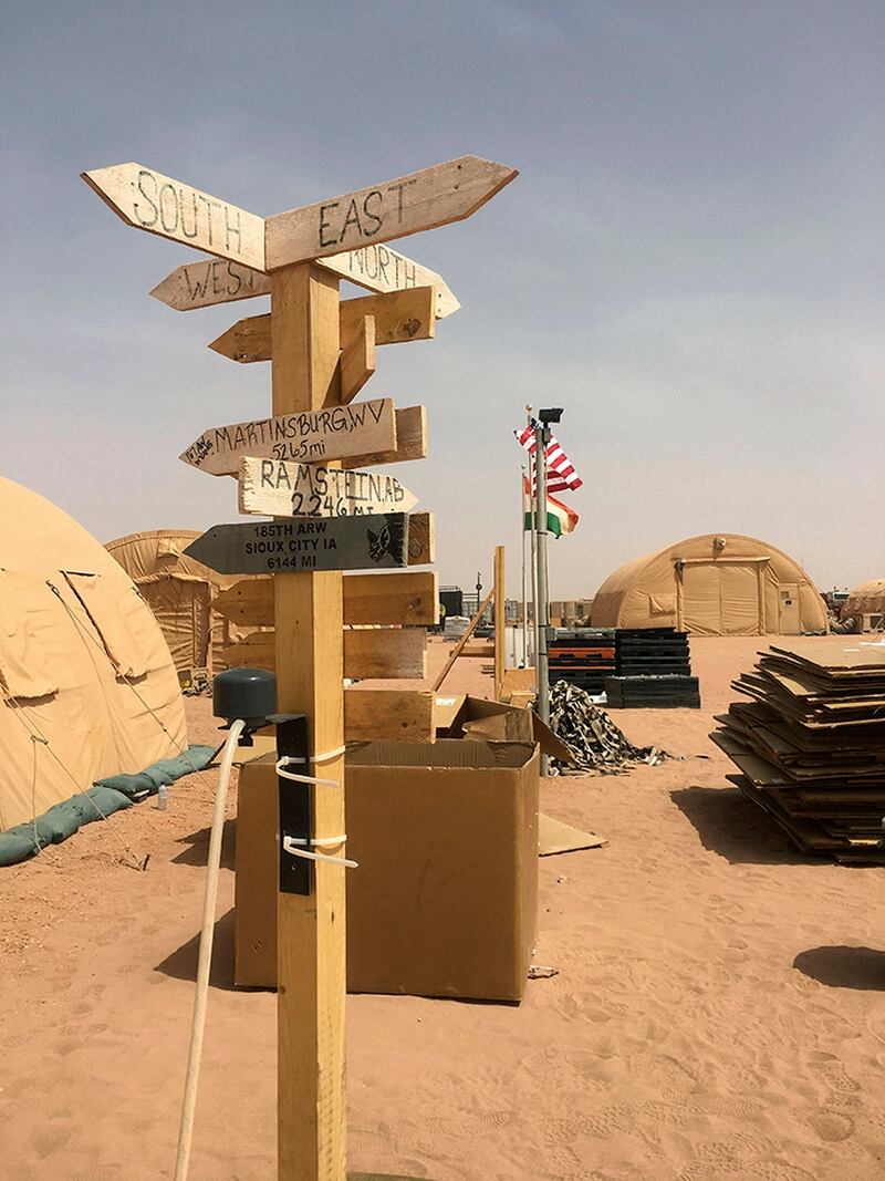 In this photo taken Monday, April 16, 2018, a direction and distance marker at the base camp for air forces and other personnel supporting the construction of Niger Air Base 201in Agadez, Niger. On the scorching edge of the Sahara Desert, the U.S. Air Force is building a base for armed drones, the newest front in America's battle against the growing extremist threat in Africa's vast Sahel region. Three hangars and the first layers of a runway command a sandy, barren field. Niger Air Base 201 is expected to be functional early next year. (Carley Petesch/AP)