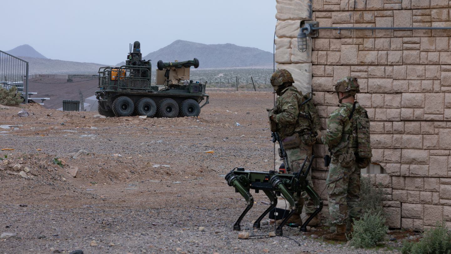 U.S. soldiers take part in a human-machine integration demonstration using Ghost Robotics' dog unmanned ground system and the Small Multipurpose Equipment Transport, background, in Fort Irwin, Calif., on March 15, 2024. (Spc. Samarion Hicks/U.S. Army)