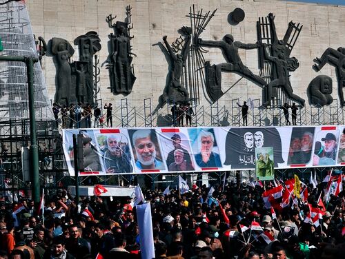 Supporters of the Popular Mobilization Forces hold a posters of Abu Mahdi al-Muhandis, deputy commander of the Popular Mobilization Forces, front, and Gen. Qassem Soleimani, head of Iran's Quds force during a protest, in Tahrir Square, Iraq, Sunday, Jan. 3, 2021. (Khalid Moha/AP)
