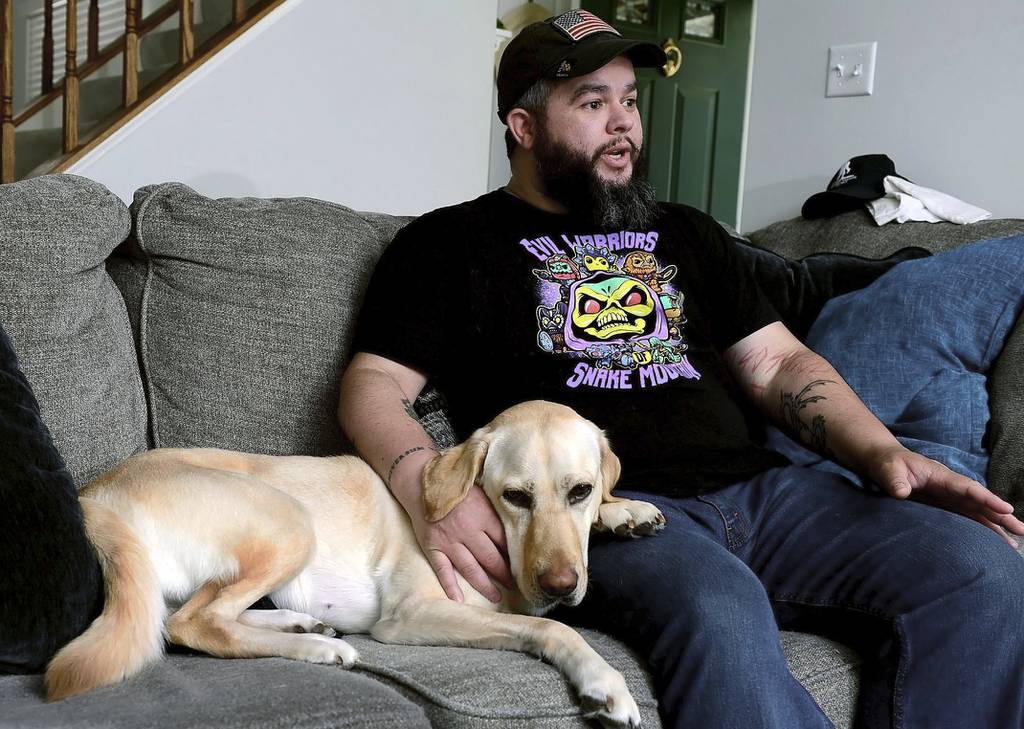 Joe Nieves, an Army veteran who was diagnosed with bipolar disorder and PTSD in 2006, talks about his service dog Jem at his home in Frederick, Md.