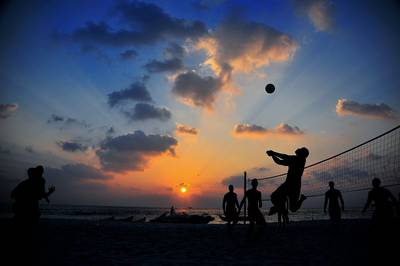 Sailors play a volleyball game on an island beach during a port visit in Maldives, Feb. 19, 2009.