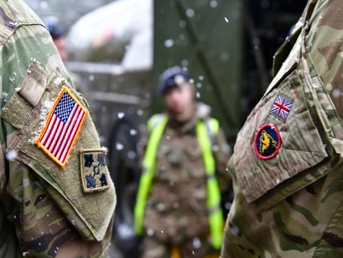 A British and an United States soldier stand side by side after a press conference on the military exercise Defender 2020 in Brueck, Germany, Wednesday, Feb. 26, 2020. (Soeren Stache/dpa via AP)