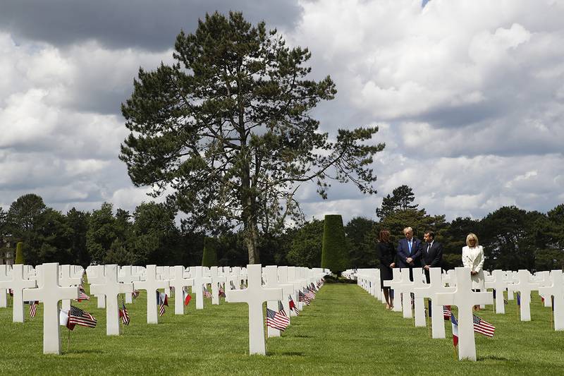 President Donald Trump, first lady Melania Trump, French President Emmanuel Macron and Brigitte Macron, walk through The Normandy American Cemetery, following a ceremony to commemorate the 75th anniversary of D-Day