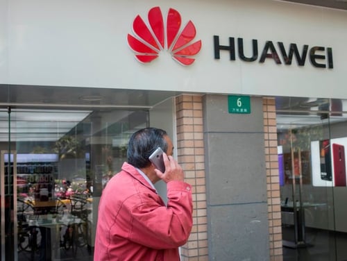 A man uses his mobile phone in front of a Huawei shop in Shanghai on May 3, 2018. U.S. officials are warning against using smartphones from Chinese cellphone maker Huawei over security concerns. (Johannes Eisele/ AFP via Getty Images)