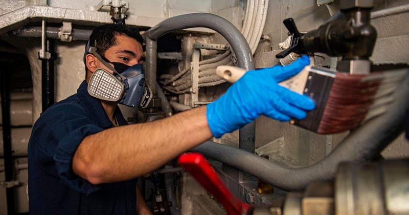 Aviation Boatswain's Mate (Equipment) Airman Alberto Romo paints the hydraulic pipe for a catapault launch valve aboard the carrier Harry S. Truman April 19. (MCSN Tyler Cardoza/Navy)
