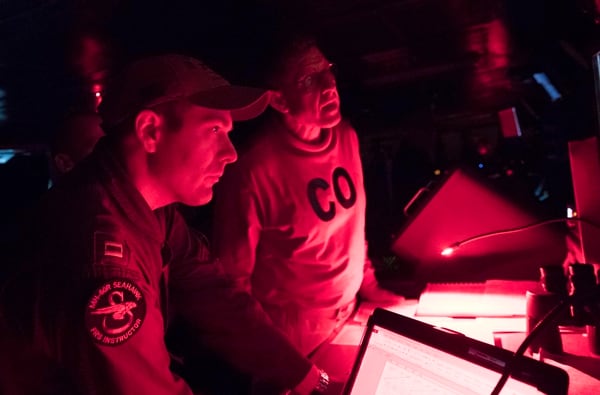 Capt. Putnam H. Browne, left, commanding officer of the aircraft carrier Abraham Lincoln and Lt. Thomas Flanagan, the ship's assistant navigator, steer the ship while transiting the Bab al-Mandeb on May 12. (Mass Communication Specialist 3rd Class Amber Smalley/Navy)