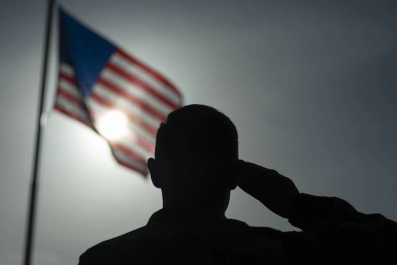 U.S. Air Force Staff Sgt. Devin Boyer, 435th Air Expeditionary Wing photojournalist, salutes the flag at Camp Simba, Kenya, Aug. 26, 2019. The 475th Expeditionary Air Base Squadron raised the flag for the first time since the base operating support-integrator mission started in 2017, signifying the change from tactical to enduring operations. (Staff Sgt. Lexie West/Air Force)