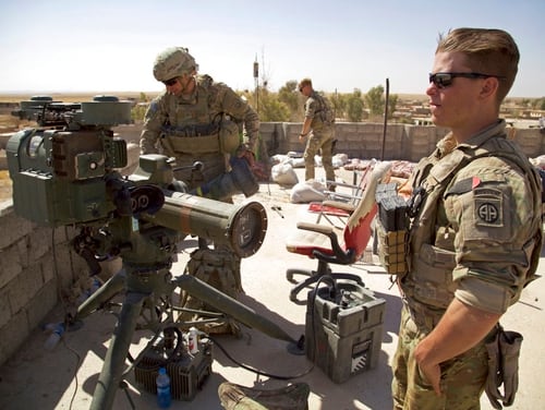 In this Aug. 20 photo, U.S. soldiers stand next to a guided-missile launcher a few miles from the frontline in the village of Abu Ghaddur, east of Tal Afar, Iraq. American troops have started to draw down from Iraq following Baghdad’s declaration of victory over the Islamic State group last year, according to western contractors at a U.S.-led coalition base in Iraq. (Balint Szlanko/AP)