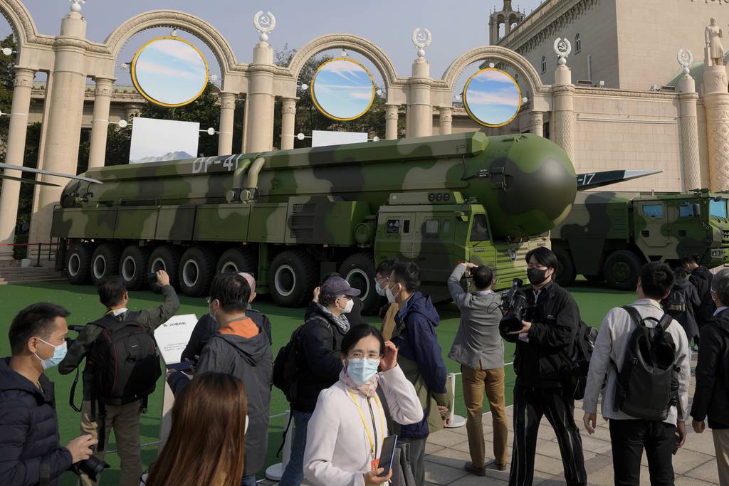 Visitors tour past military vehicles carrying the Dong Feng 41 and DF-17 ballistic missiles at an exhibition highlighting President Xi Jinping and his China's achievements under his leadership, at the Beijing Exhibition Hall in Beijing on Oct. 12, 2022.