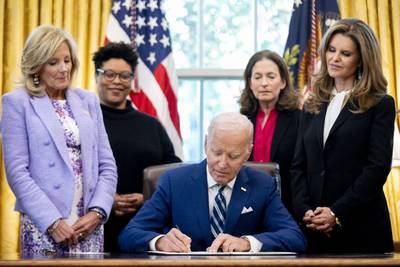 President Joe Biden, accompanied by from left, first lady Jill Biden, Office of Management and Budget director Shalanda Young, White House Gender Policy Council director Jen Klein, and Women's Alzheimer's Movement founder Maria Shriver, signs a presidential memorandum that will establish the first-ever White House Initiative on Women's Health Research in the Oval Office of the White House, Monday, Nov. 13, 2023, in Washington.