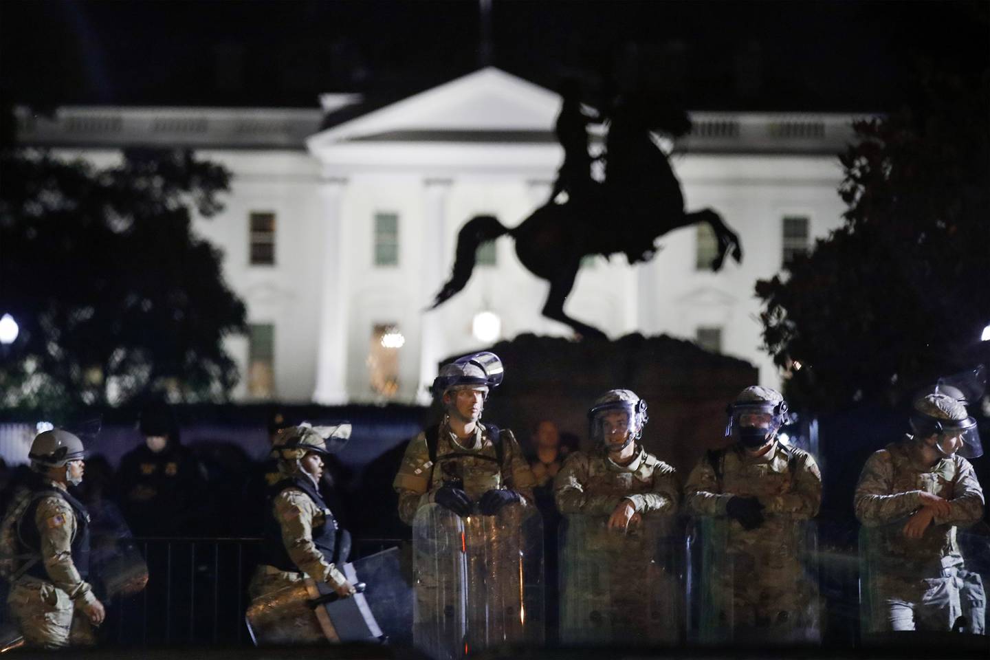 A line of DC National Guard members stand in Lafayette Park as demonstrators gather to protest the death of George Floyd, Tuesday, June 2, 2020, near the White House in Washington
