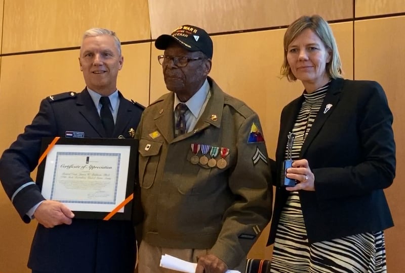 Dr. James W. Baldwin, a corporal who served in the 784th Tank Battalion, receives a certificate from Air Commodore Paul Herber and Deputy Chief of Mission Heleen Bakker at the Dutch Embassy on Feb. 6, 2020. (Courtesy of the Embassy of the Kingdom of the Netherlands/Jeffrey Allanach)