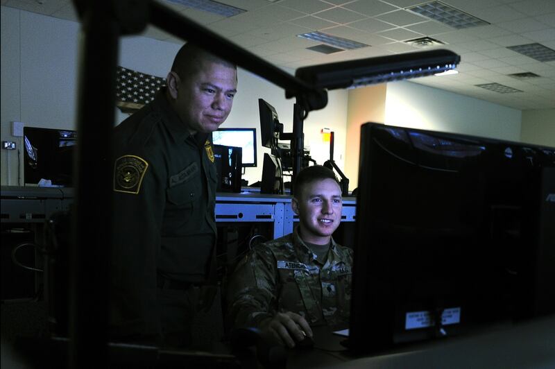 A Wisconsin National Guard member and a Customs and Border Patrol Agent review surveillance video footage shot along the border in Nogales, Ariz. (Sgt. 1st Class Jon Soucy/Army)