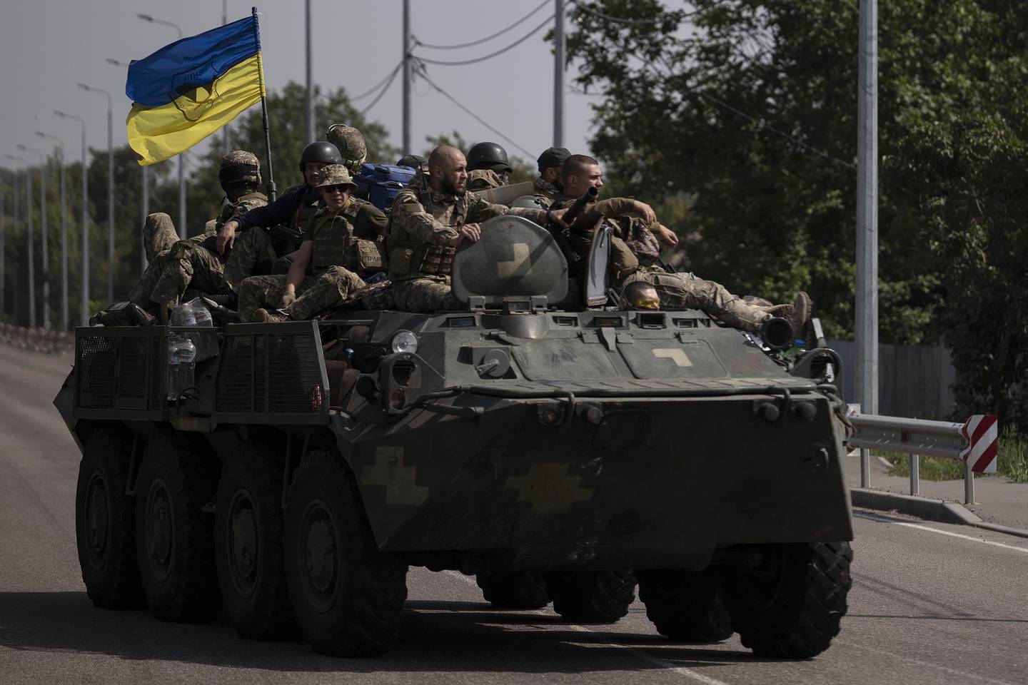 Ukrainian servicemen ride atop of an armored vehicle on a road in Donetsk region, eastern Ukraine, Sunday, Aug. 28, 2022.