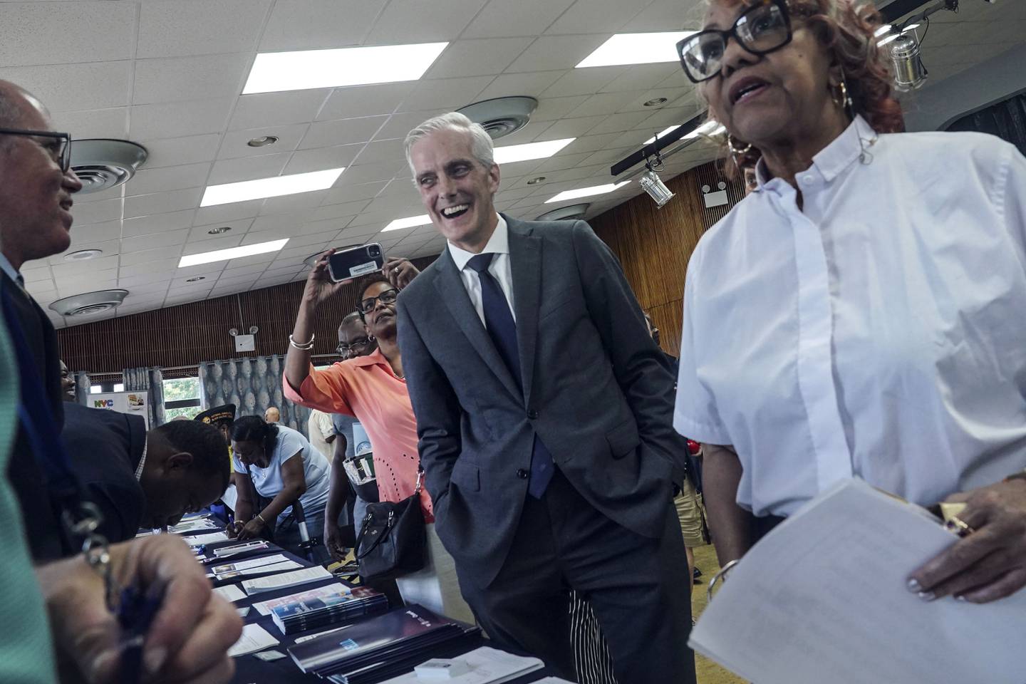 Veterans Affairs Secretary Denis McDonough, center, meets with attendees at a resource fair for veterans and survivors to apply for benefits under the PACT Act, Wednesday Aug. 2, 2023, in New York.