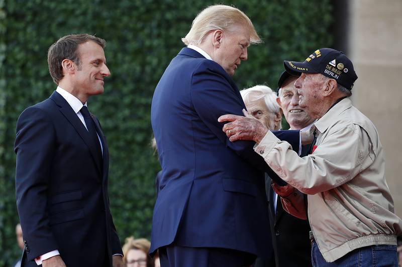 President Donald Trump and French President Emmanuel Macron, talk to a World War II veteran during a ceremony to commemorate the 75th anniversary of D-Day at the American Normandy cemetery
