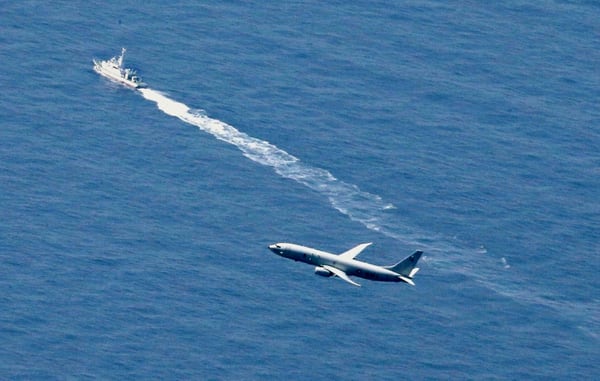 A Japanese Coast Guard vessel and a U.S. military plane search for a Japanese fighter jet, in the waters off Aomori, northern Japan, on April 10, 2019. (Kyodo News via AP)