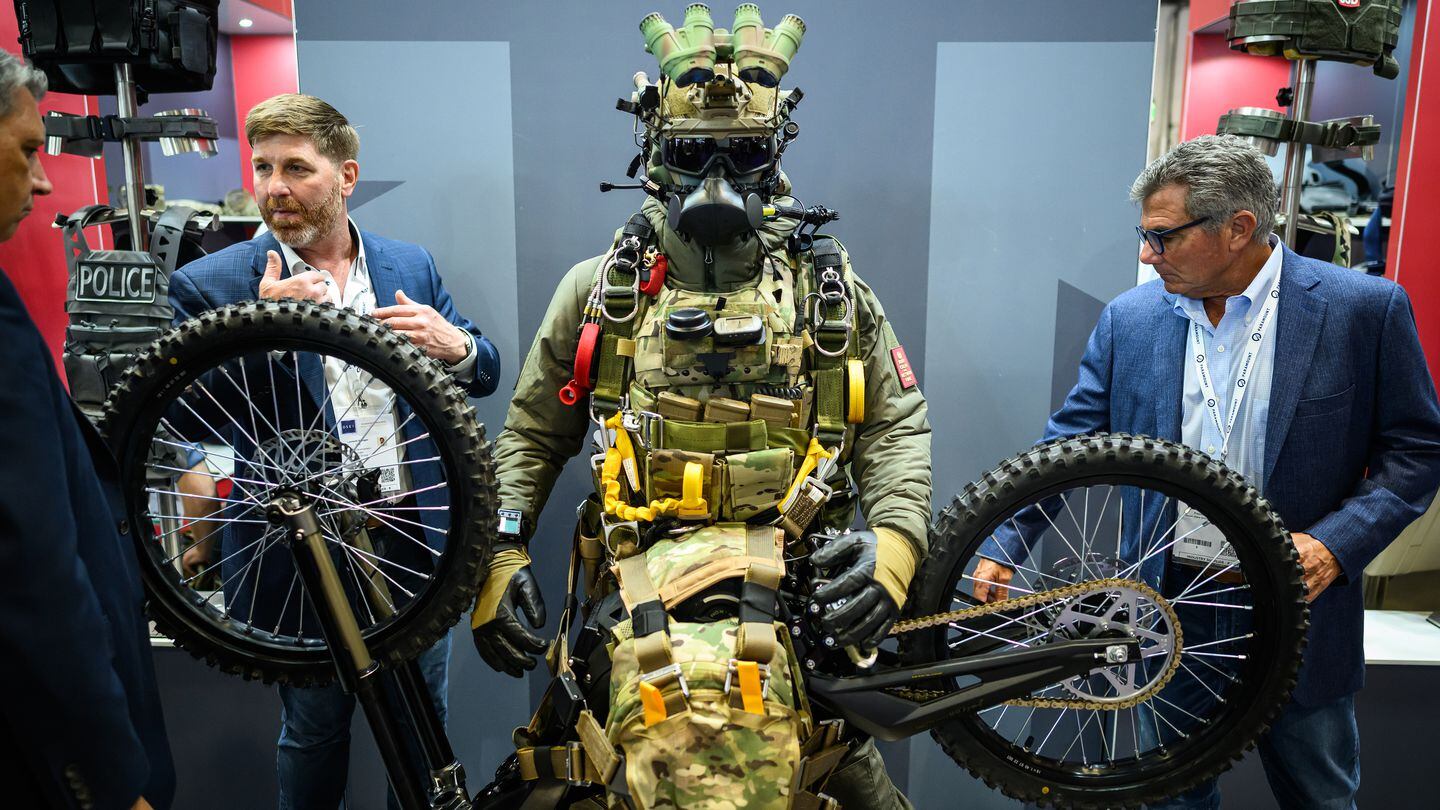 DSEI visitors examine the hardware, equipment and clothing worn by a mannequin on the C2R display stand on Sept. 13, 2023. (Leon Neal/Getty Images)