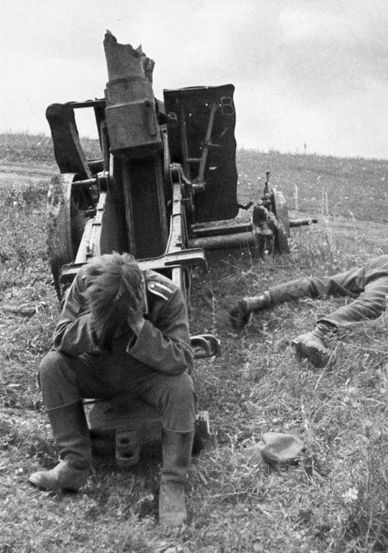 Temmuz 1943'teki Kursk muharebesi sırasında yurttaşlarından birinin cesedi ve tahrip edilmiş bir ağır top silahı ve yurttaşlarından birinin cesediyle başını elinde oturan bir Alman askeri. (V.Kinelovsky / Slava Katamidze Koleksiyonu / Getty Images)