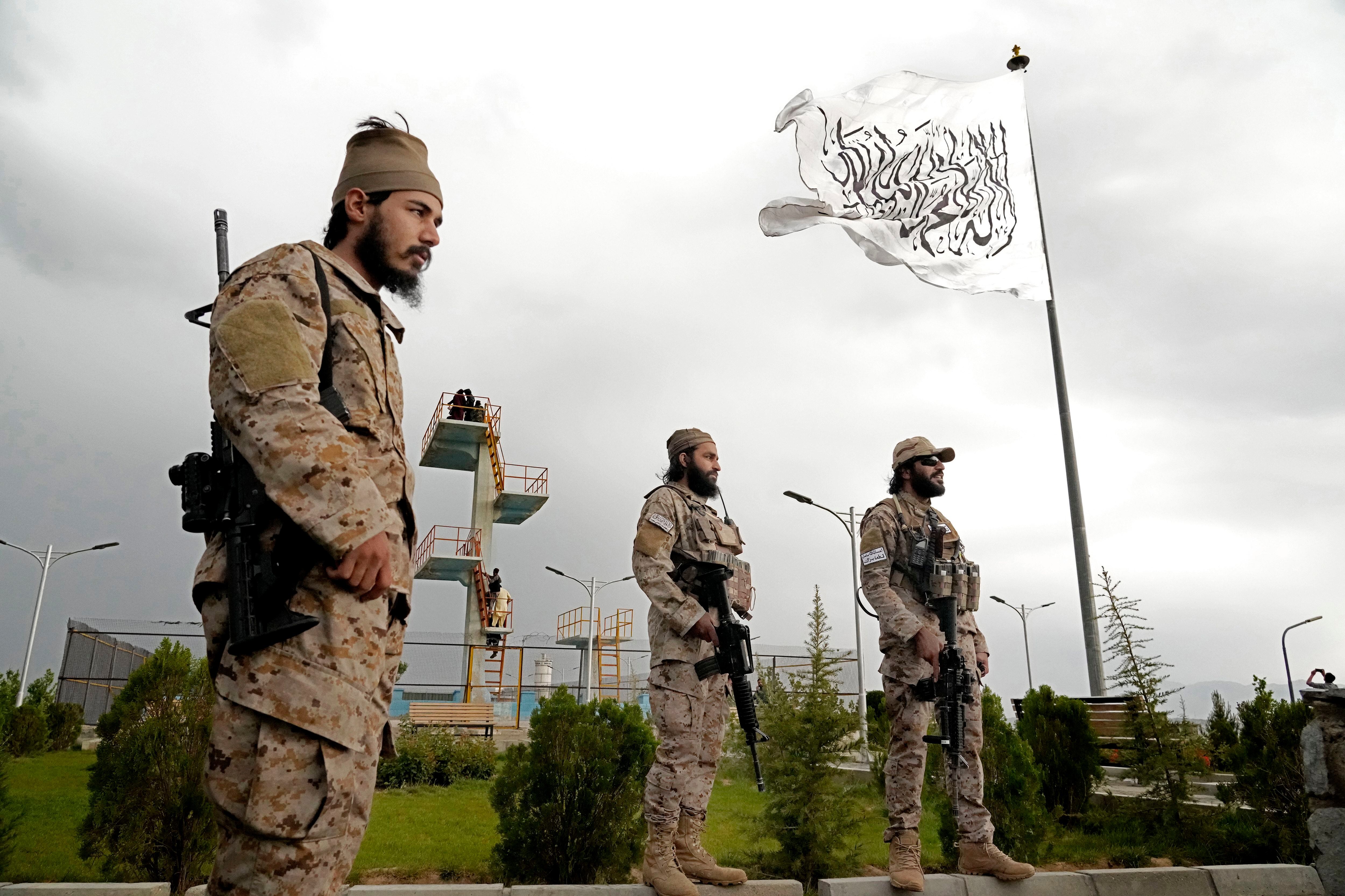 Taliban special forces stand guard in front of the Taliban flag at a park in Kabul, Afghanistan, Monday, April 18, 2022. (AP Photo/Ebrahim Noroozi)