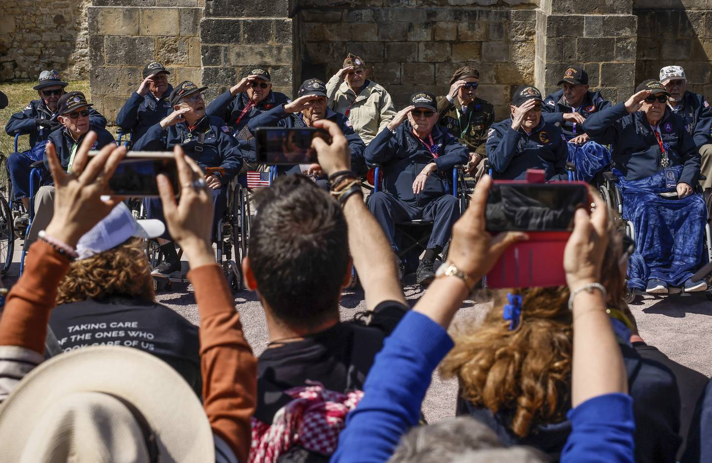 U.S. veterans salute as they pose for photographs after a parade in preparation of the 79th D-Day anniversary in Sainte-Mere-Eglise, Normandy, France, Sunday, June 4, 2023.