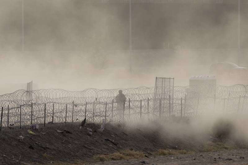 A Texas National Guard soldier stands guard in an emptied out migrant camp at the U.S.-Mexico border on May 13, 2023 to El Paso, Texas.