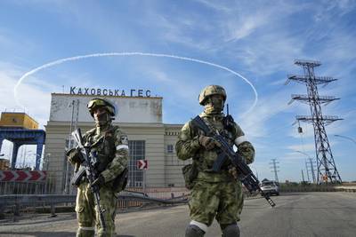 Russian troops guard an entrance of the Kakhovka Hydroelectric Station, a run-of-river power plant on the Dnieper River in the Kherson region, south Ukraine, Friday, May 20, 2022.