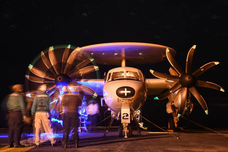 U.S. sailors inspect a propeller on an E-2C Hawkeye on the flight deck of the aircraft carrier USS Theodore Roosevelt (CVN 71) in the Pacific Ocean on Jan. 5, 2021.