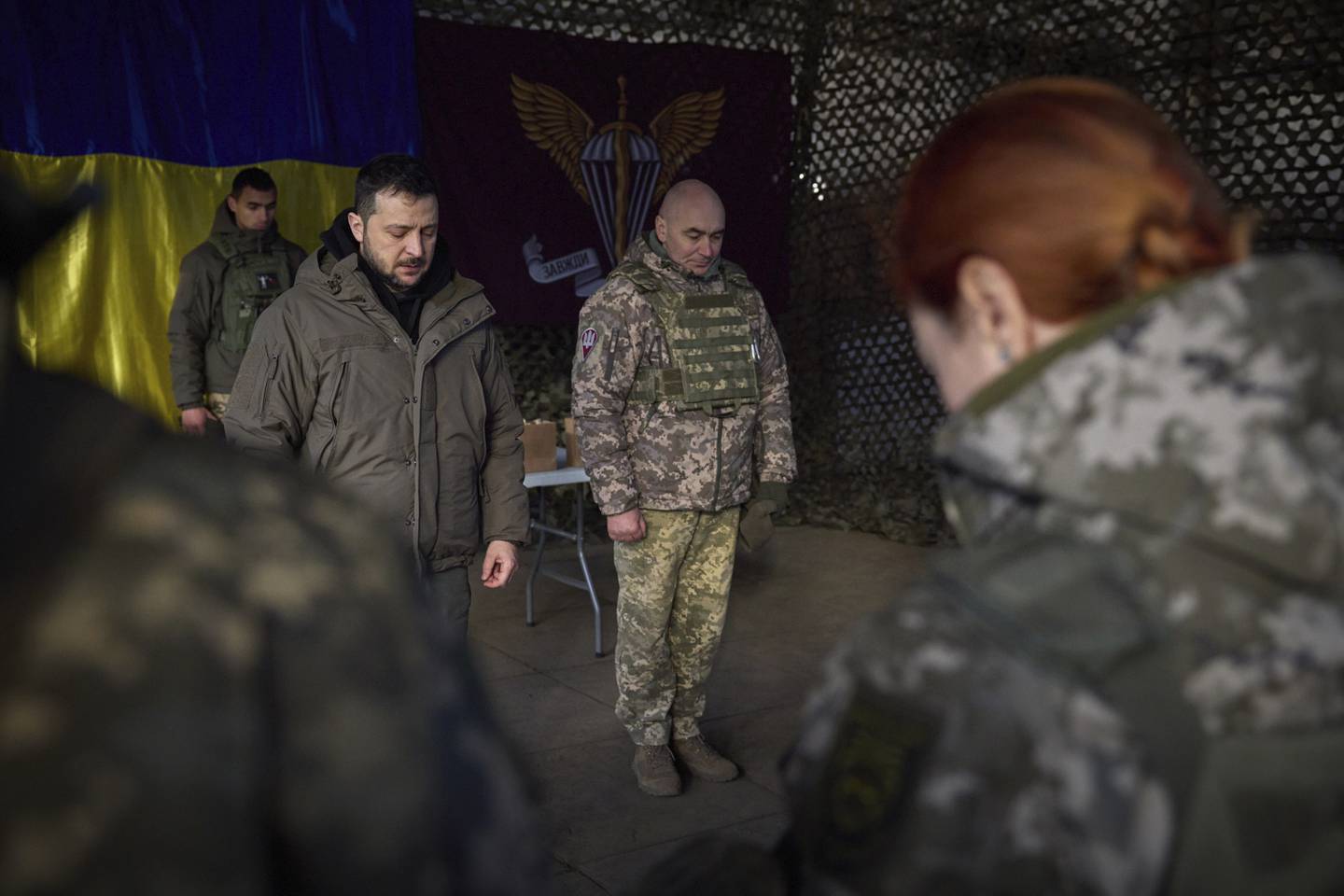 In this photo provided by the Ukrainian Presidential Press Office, Ukrainian President Volodymyr Zelenskyy, center left, stands along servicemen during a minute of silence in honor of soldiers killed during fighting with Russian troops as he visits the Sloviansk, Donbas region, Ukraine, Tuesday, Dec. 6, 2022.
