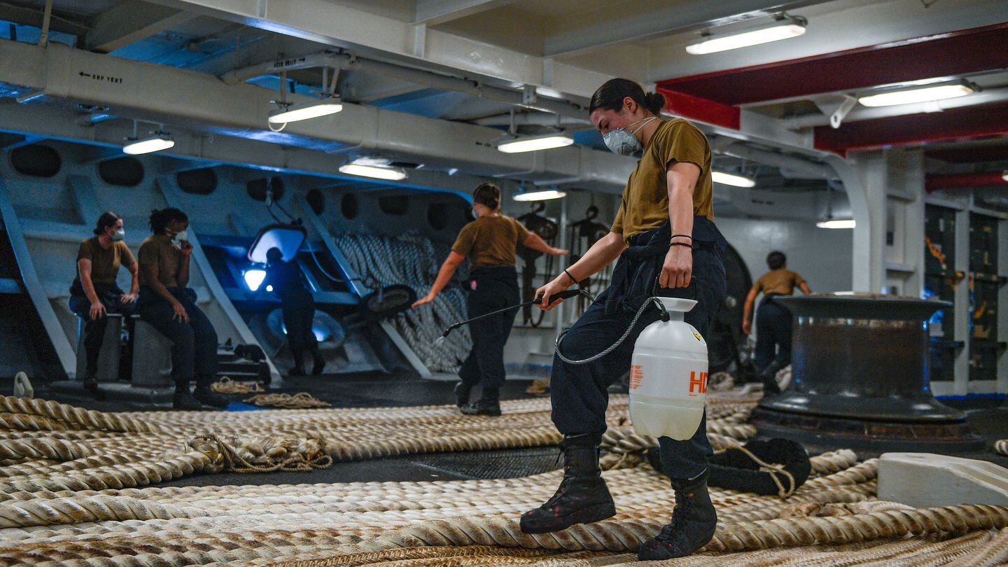 Boatswain’s Mate Seaman Alexis Bias disinfects mooring line aboard the aircraft carrier Theodore Roosevelt on May 21, 2020, following an extended visit to Guam in the midst of the COVID-19 pandemic. (MC3 Conner D. Blake/Navy)