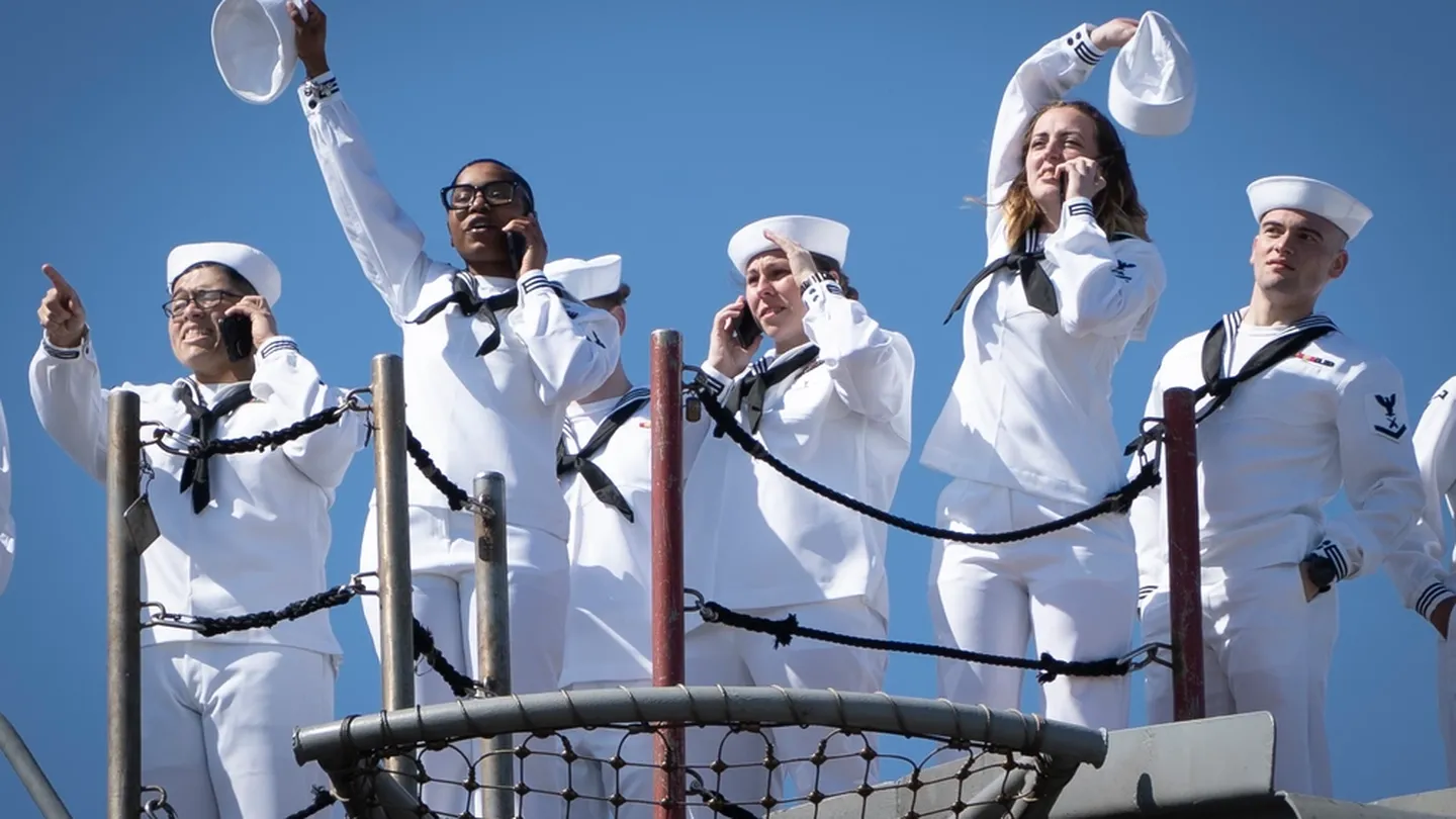 Sailors assigned to the aircraft carrier George H.W. Bush, along with the staff of carrier Strike Group 10, wave to family members as the ship returns to Naval Station Norfolk following an eight-month deployment, April 23. (MC2 Anderson W. Branch/Navy)