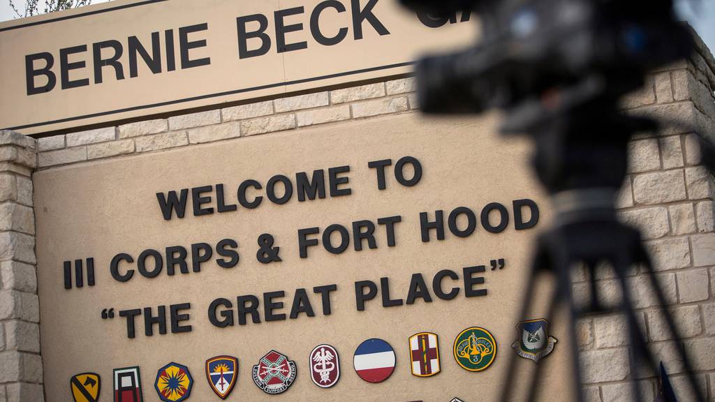 In this April 2, 2014, file photo, members of the media wait outside of the Bernie Beck Gate, an entrance to the Fort Hood military base in Fort Hood, Texas
