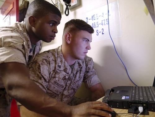 Gunnery Sgt. Lagarian Smith, cyber network chief with the 13th Marine Expeditionary Unit, guides Cpl. Justin Henderson, a 13th MEU cyber network specialist, through troubleshooting techniques as they set up network communications aboard the USS Boxer during PHIBRON-MEU Intergration (PMINT) exercise Sept. 24, 2015. The exercise marks the first time 13th MEU Marines and Sailors with the Boxer Amphibious Ready Group get to work together at sea before their deployment to the Pacific and Central Command areas of responsibility in early 2016. (U.S. Marine Corps photo by: Staff Sgt. Terika S. King/Relased)
