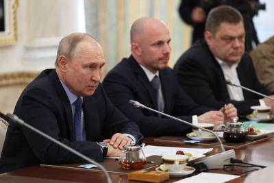 Russian President Vladimir Putin, left, speaks during a meeting with Russian war correspondents who cover a special military operation at the Kremlin in Moscow, Russia, Tuesday, June 13, 2023.
