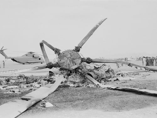 The rotor blades of a burned-out U.S. helicopter create a stark silhouette against the desert skies of eastern Iran, where the American commando mission to rescue the hostages proved impossible after equipment failure, seen April 27, 1980. In background is a U.S. helicopter that was also left behind when the mission was aborted. (AP Photo)