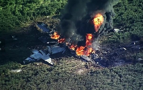 In this Monday, July 10, 2017 frame from video, smoke and flames rise from a military plane that crashed in a farm field, in Itta Bena, Miss., killing several. (WLBT-TV via AP)