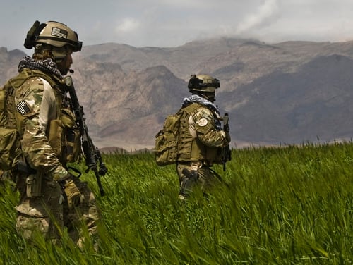 Special operations soldiers patrol a field in Farah, Afghanistan, alongside Afghan National Army commandos. (Spc. Joseph A. Wilson/Army)