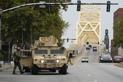 Military vehicles enter the city ahead of a 9 p.m. curfew, Wednesday, Sept. 23, 2020, in Louisville, Ky.