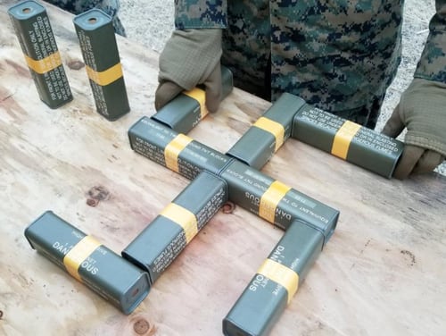 Military explosives arranged in the shape of a swastika. (Screenshot of Tweet from Twitter account @Jacobite_Edward)