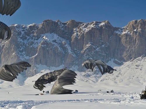 Pallets of supplies land on snow covered ground during an airdrop in Zabul province, Afghanistan, in 2012. (DoD)