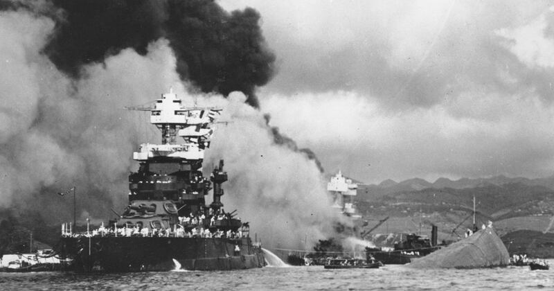 In this Dec. 7, 1941, file photo, part of the hull of the capsized battleship Oklahoma is seen at right as the battleship West Virginia, center, begins to sink after suffering heavy damage, while the battleship Maryland, left, is still afloat in Pearl Harbor, Oahu, Hawaii. Floyd Welch, one of the last survivors of that battle, was serving aboard the USS Maryland when the U.S. fleet came under attack by Japan. (U.S. Navy via AP, File)