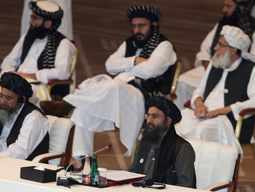 In this Sept. 12, 2020, file photo, Taliban co-founder Mullah Abdul Ghani Baradar, bottom right, speaks at the opening session of peace talks between the Afghan government and the Taliban in Doha, Qatar. (Hussein Sayed/AP)
