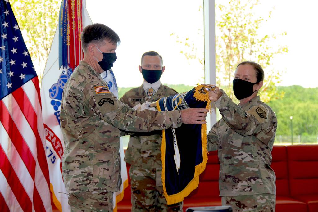 Lt. Gen. Stephen G. Fogarty, commander of U.S. Army Cyber Command, left, and ARCYBER senior enlisted leader Command Sgt. Maj. Sheryl D. Lyon, right, unfurl the ARCYBER colors in the command's new headquarters at Fort Gordon, Ga., July 24, 2020.