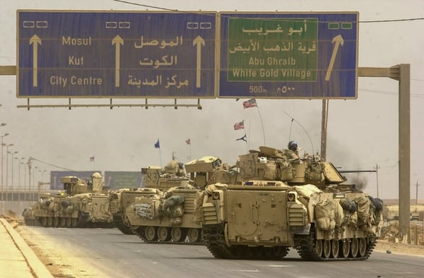 Vehicles from the Army's 3rd Infantry Division move to the northwestern side of the city to complete the encirclement of Baghdad, Iraq, during the early days of the war. (Warren Zinn/Staff)