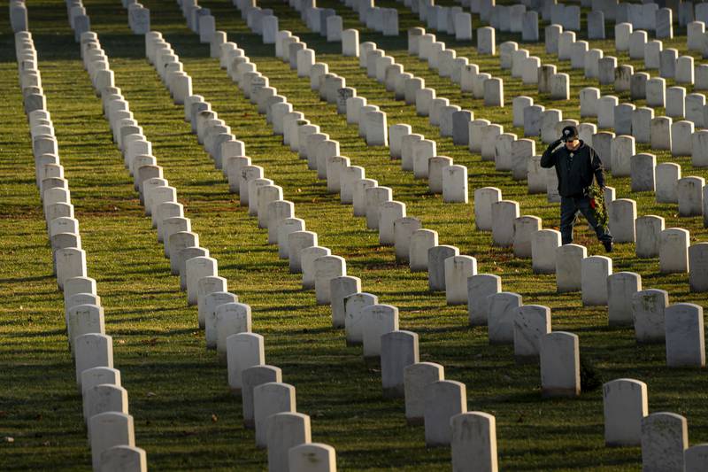 A man salutes after placing a wreath at Arlington National Cemetery, Saturday, Dec. 16, 2023, in Arlington, Va.