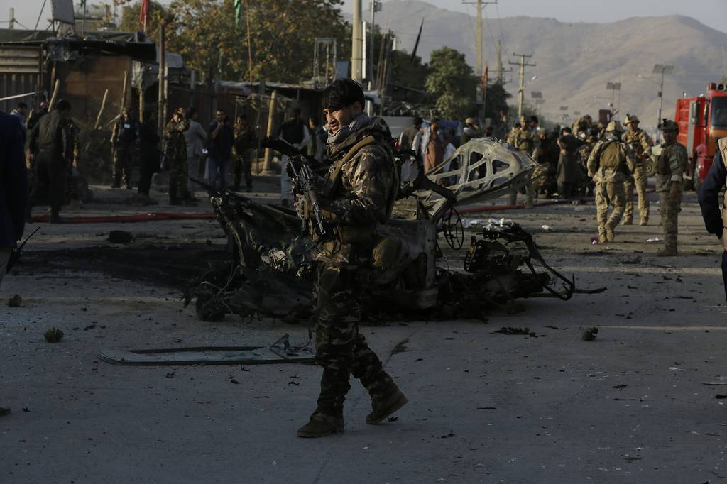Afghan security personnel stand guard after a car bomb explosion in Kabul, Afghanistan,Tuesday, Oct. 27, 2020.