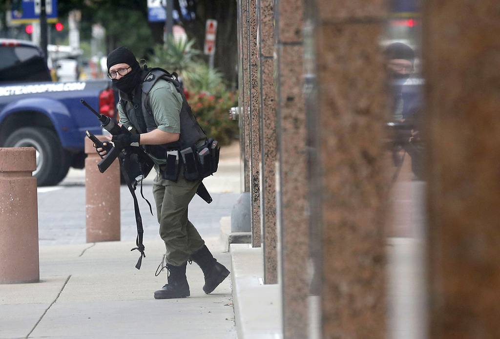 An armed shooter stands near the Earle Cabell Federal Building Monday, June 17, 2019, in downtown Dallas.