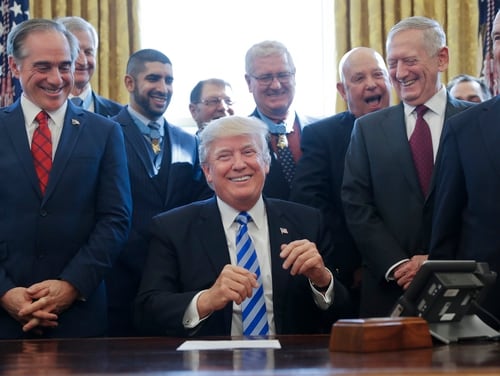 President Donald Trump smiles during a ceremony with Medal of Honor recipients at the White House on March 24, 2017. At left is then-Secretary of Veterans Affairs David Shulkin, whose new book details chaos and confusion within the administration before his firing in 2017. (Pablo Martinez Monsivais/AP)