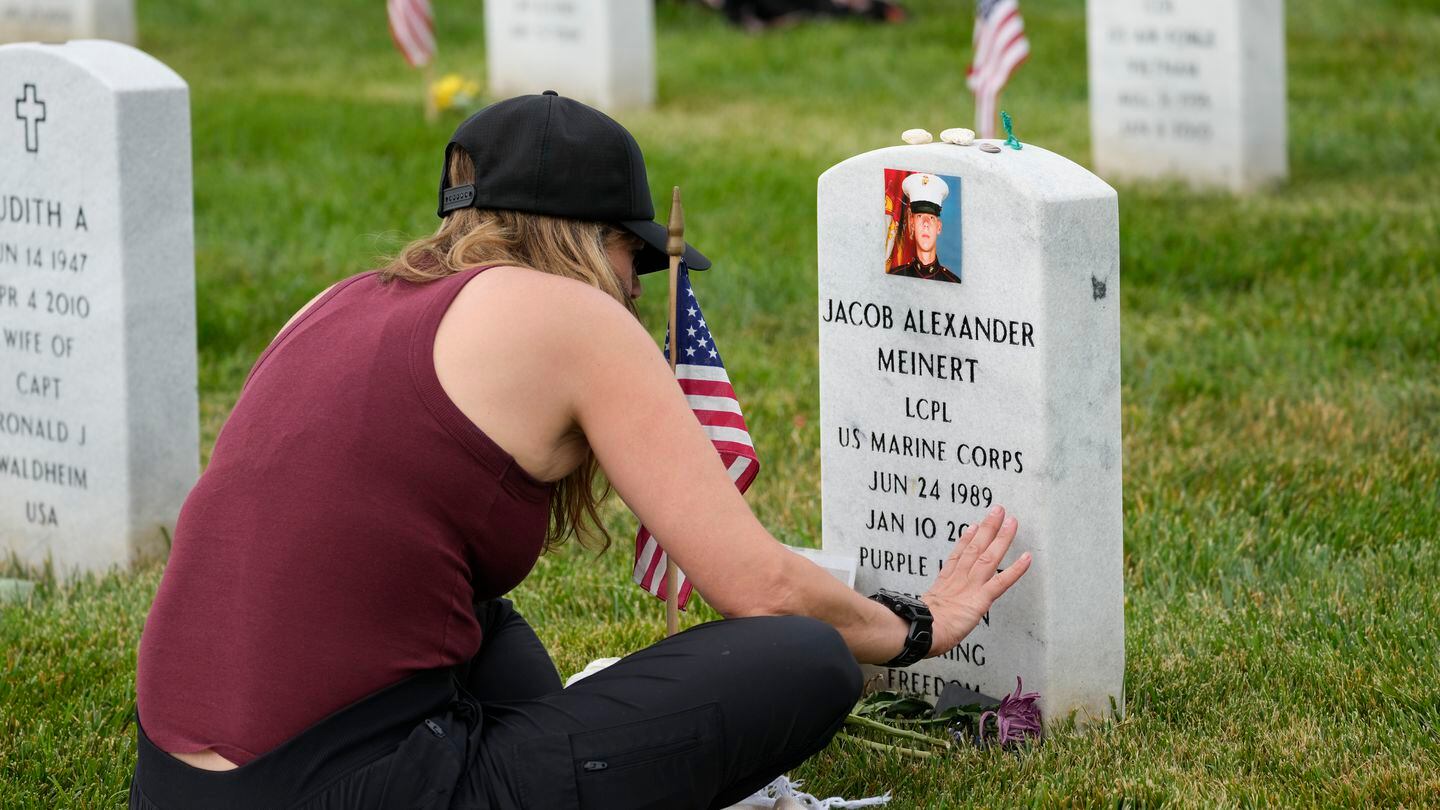 Krista Meinert touches the headstone of her son in Arlington National Cemetery on Memorial Day. Marine Lance Cpl. Jacob Alexander Meinert, of Fort Atkinson, Wisconsin, was with 1st Battalion, 3rd Marine Regiment, 3rd Marine Division, when he stepped on a landmine in Helmand  province, Afghanistan, Jan. 10, 2010. (Alex Brandon/AP)