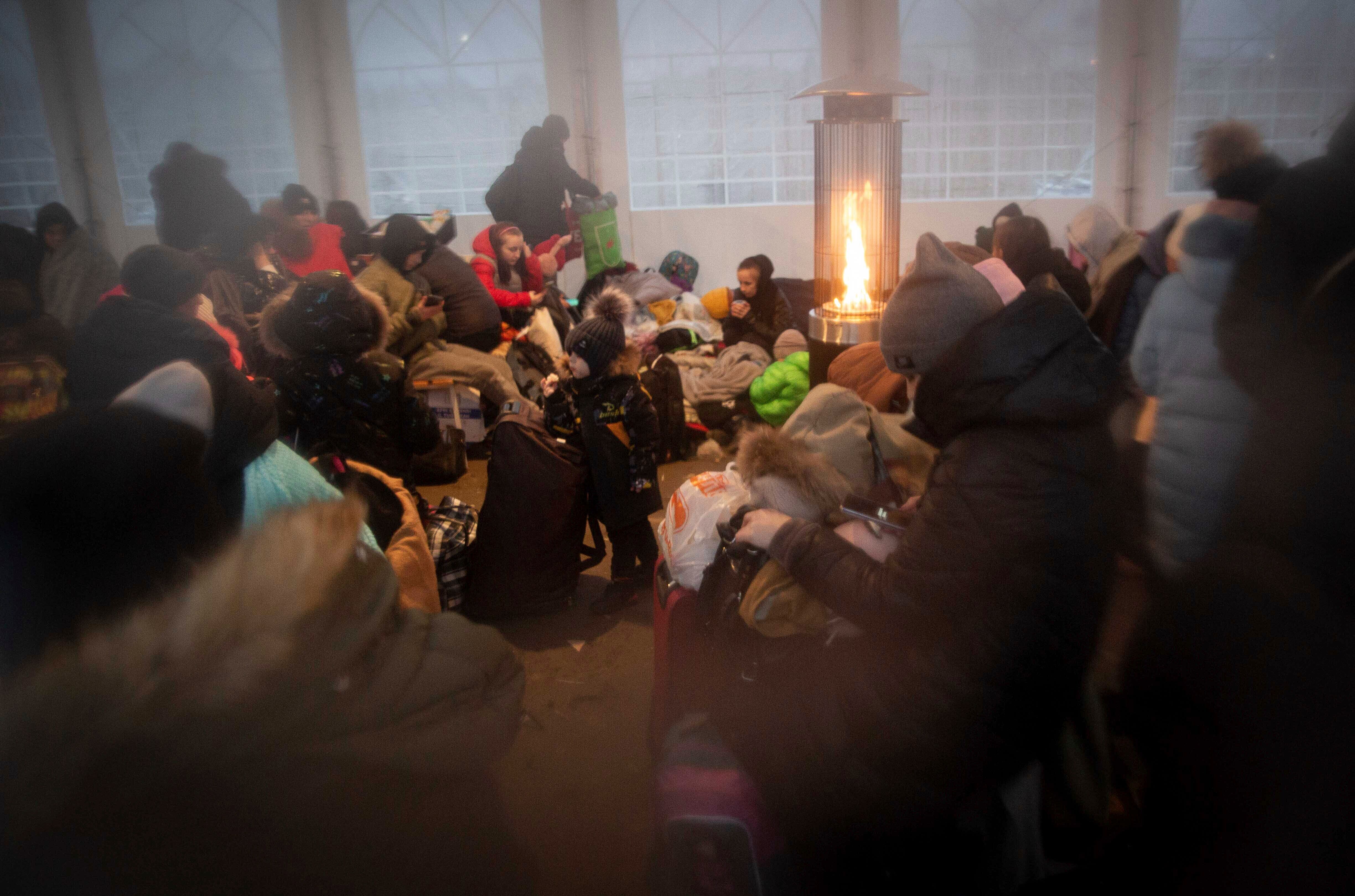 Refugees, mostly women with children, rest inside a tent after arriving at the border crossing, in Medyka, Poland on Sunday, March 6, 2022. (Visar Kryeziu/AP)